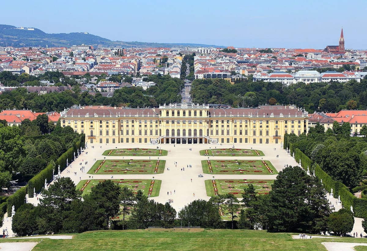 Fasad kuning Istana Schönbrunn dengan taman formal di depannya
