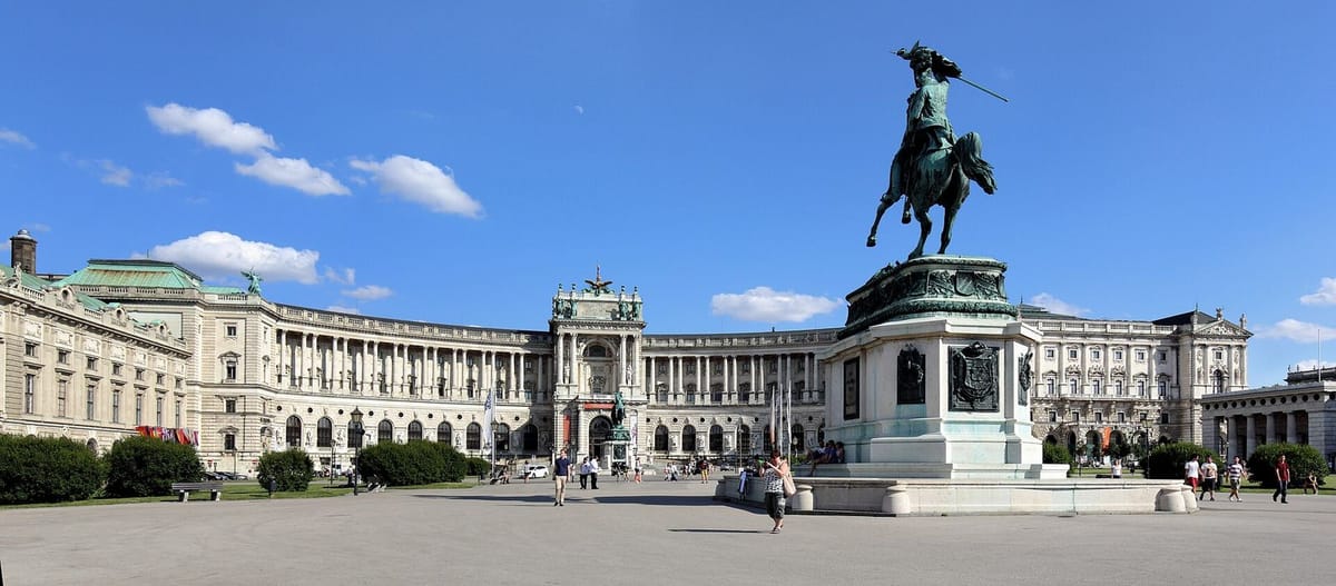 Fasad Istana Hofburg dengan lapangan dan patung di pusat Wina