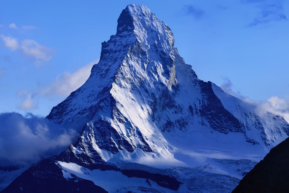 Puncak piramida Matterhorn bersalju di atas lanskap Alpen