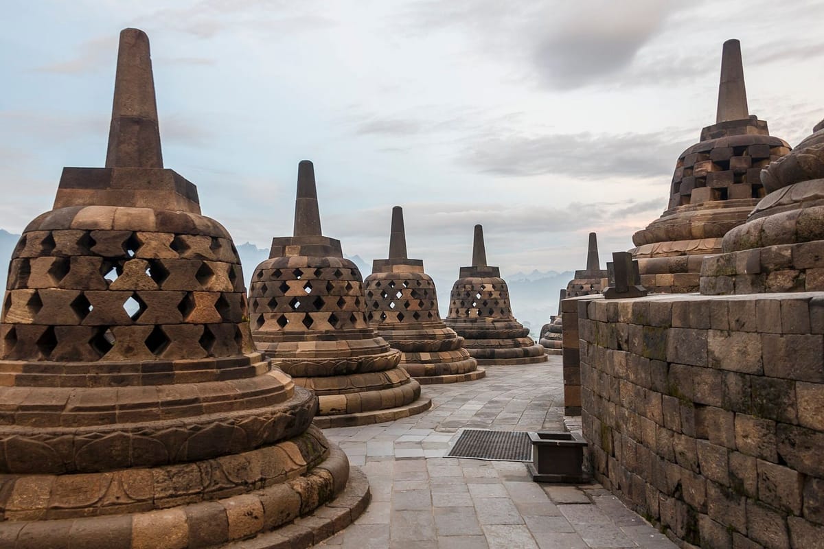 Stupa berlubang di teras atas Candi Borobudur dengan latar pegunungan