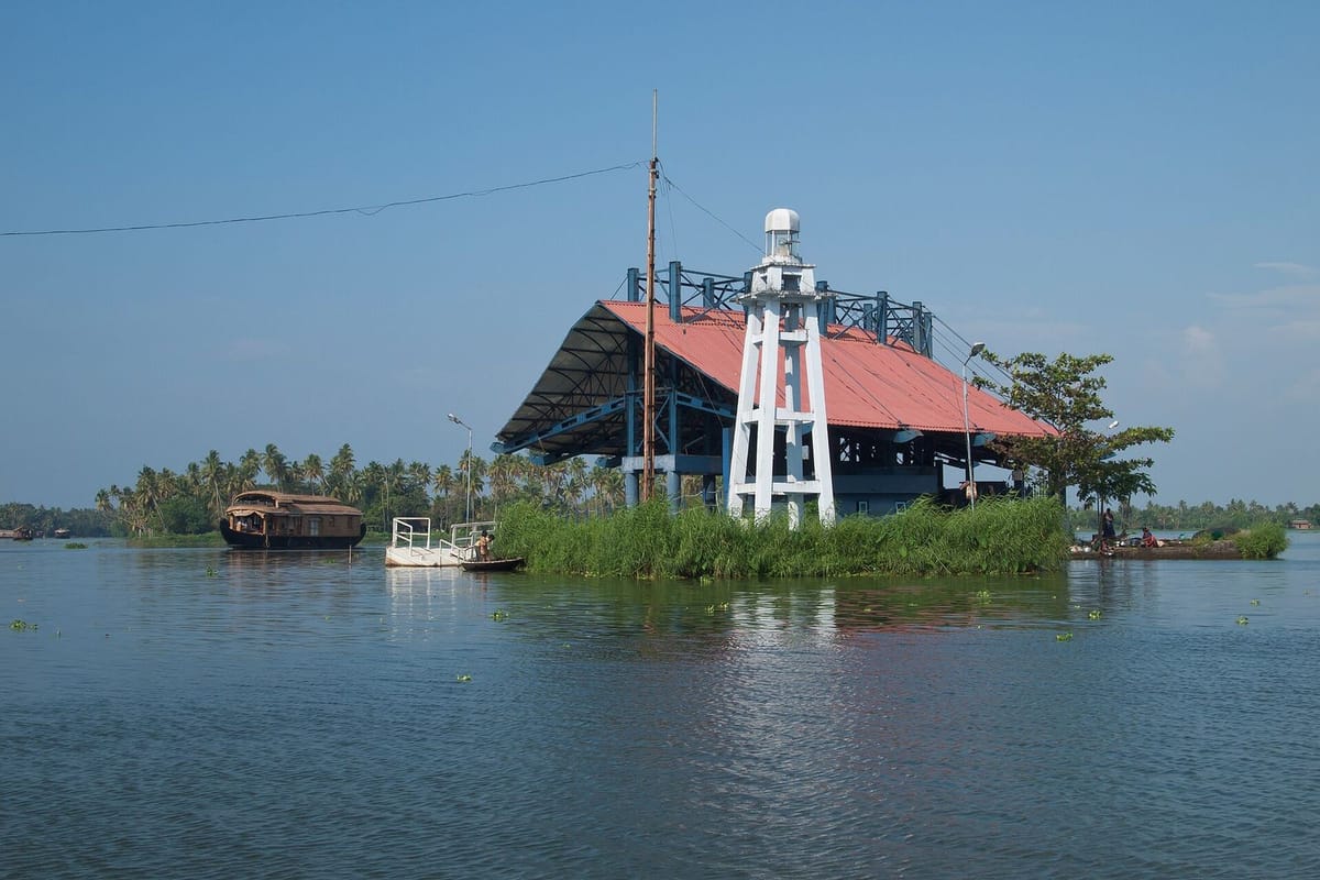 Perahu rumah di perairan tenang Kerala dikelilingi pohon kelapa