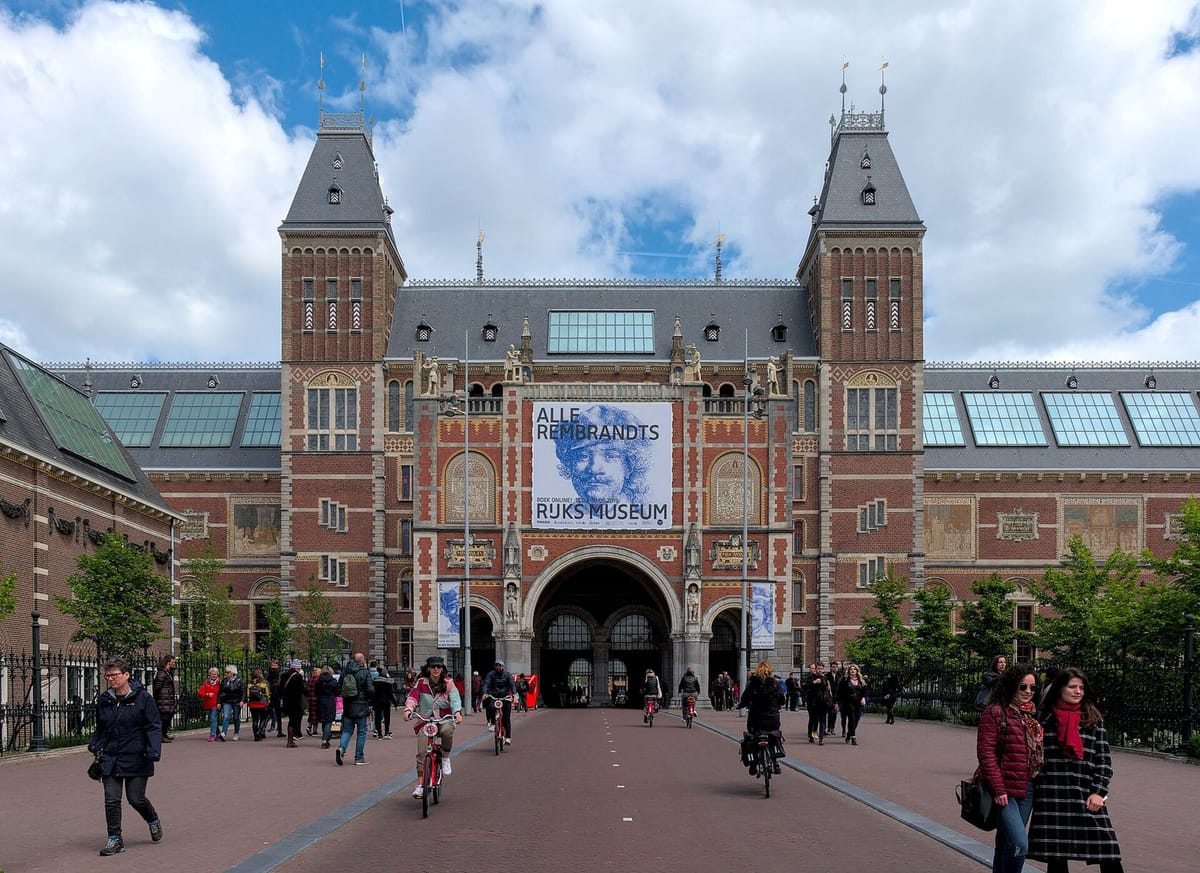Fasad Rijksmuseum dengan kolam dan taman di Museumplein, Amsterdam