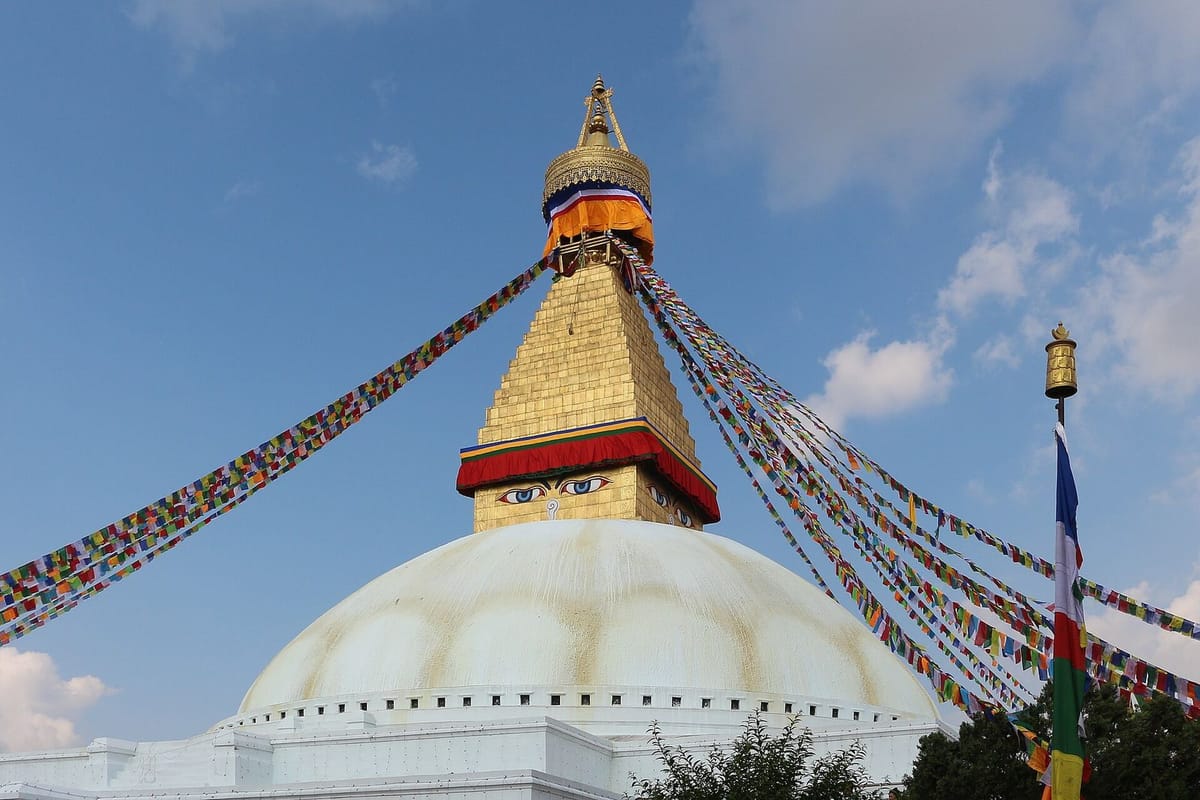 Stupa Boudhanath dengan mata Buddha dan bendera doa di Kathmandu