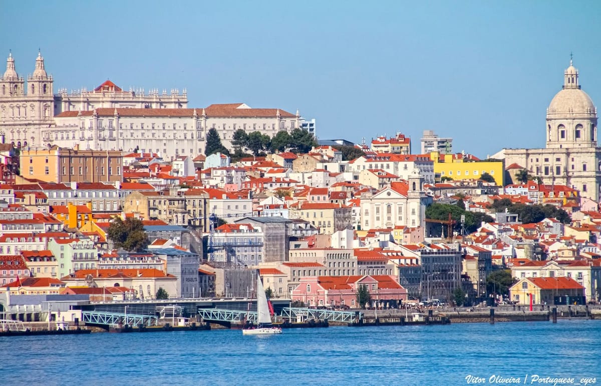 Tram kuning menuruni bukit berbatu di Lisbon